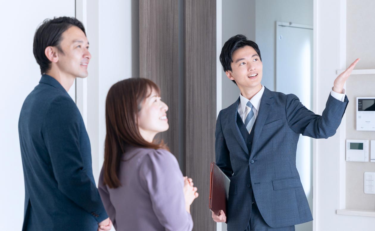 営業担当者が住宅を案内し、顧客が安心して購入を決められるようサポートしているシーン